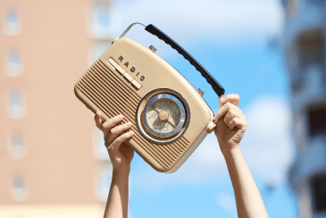 Old Time Radio Being Held in Air By Hands